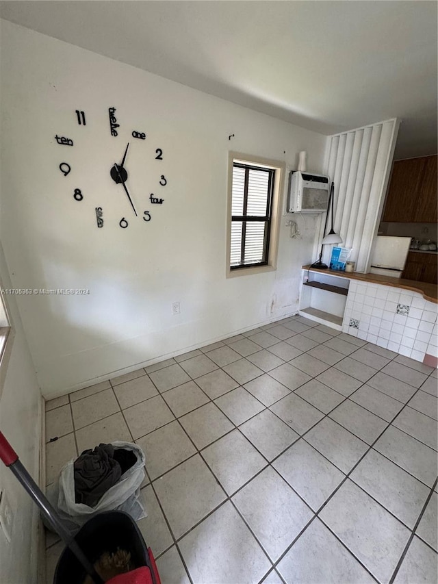 tiled spare room featuring a wall unit AC