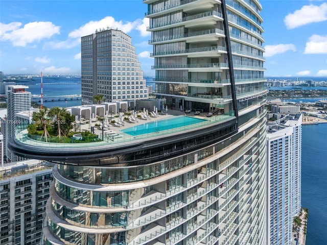 view of building exterior featuring a water view and a city view