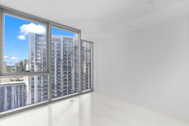 unfurnished room with floor to ceiling windows and a city view