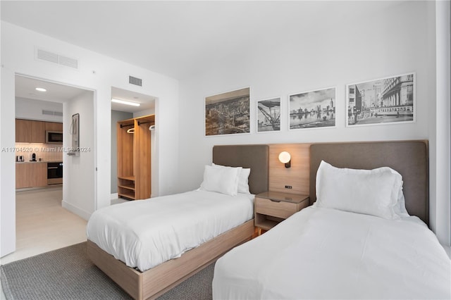 tiled bedroom featuring a spacious closet and a closet