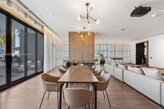 dining area with wood-type flooring and an inviting chandelier