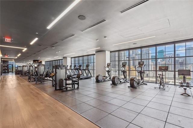 exercise room with expansive windows and hardwood / wood-style flooring