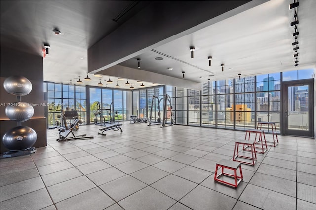 exercise room with tile patterned flooring, track lighting, and floor to ceiling windows