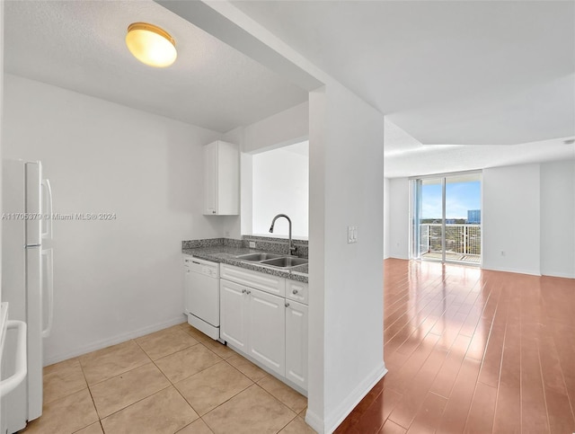 kitchen with sink, light hardwood / wood-style floors, a textured ceiling, white appliances, and white cabinets