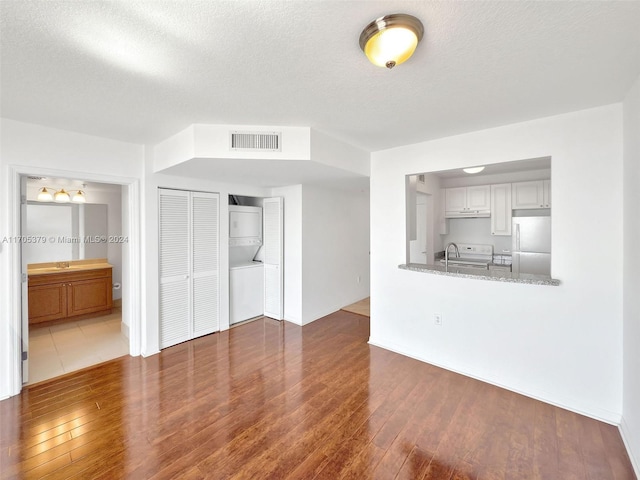 unfurnished living room featuring a textured ceiling and dark wood-type flooring