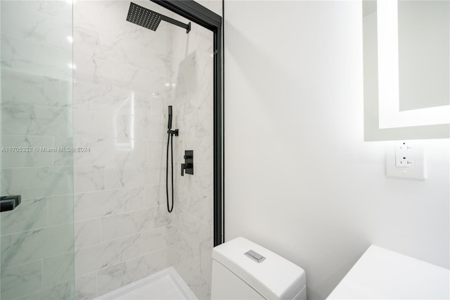 bathroom with toilet and a tile shower