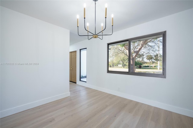 interior space featuring an inviting chandelier and light hardwood / wood-style flooring