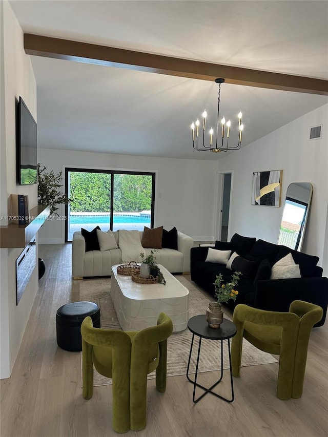 living room with an inviting chandelier, vaulted ceiling with beams, and light hardwood / wood-style flooring