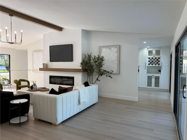 living room featuring an inviting chandelier, lofted ceiling with beams, and light hardwood / wood-style floors