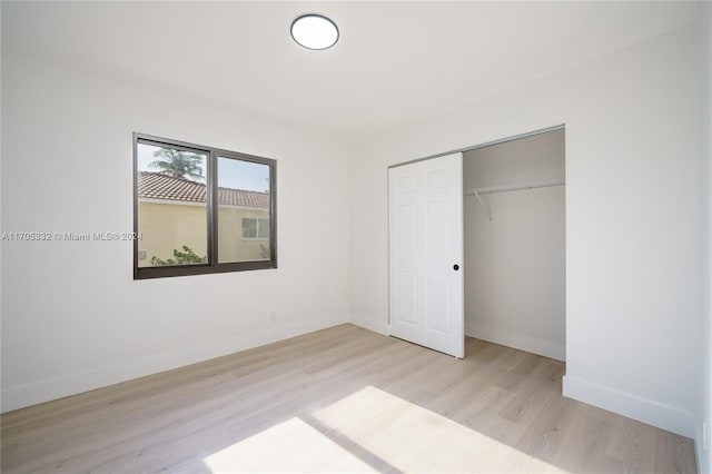 unfurnished bedroom with light hardwood / wood-style floors and a closet