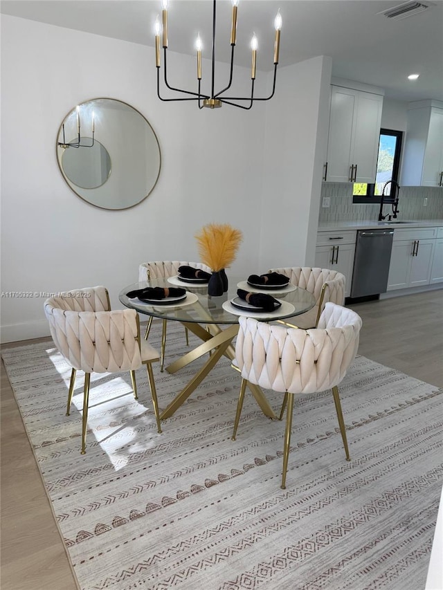 dining space with a chandelier and light hardwood / wood-style flooring