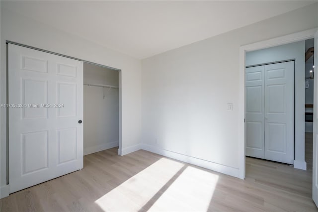 unfurnished bedroom with a closet and light hardwood / wood-style flooring