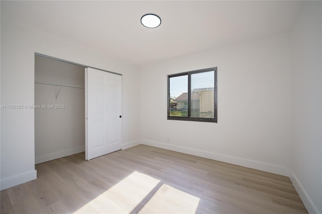 unfurnished bedroom with light hardwood / wood-style floors and a closet