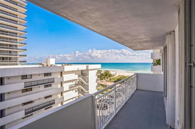 balcony featuring a view of the beach and a water view