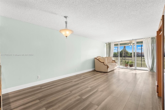 unfurnished room with a textured ceiling, light hardwood / wood-style floors, and expansive windows