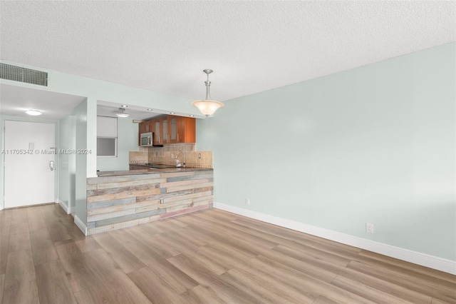 kitchen featuring light wood-type flooring and a textured ceiling