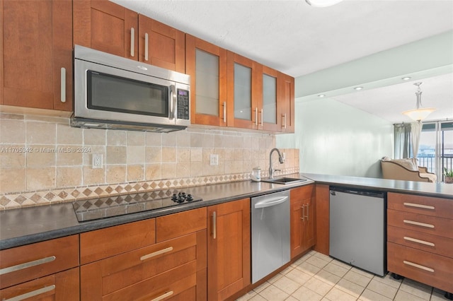 kitchen featuring decorative backsplash, appliances with stainless steel finishes, sink, light tile patterned floors, and pendant lighting