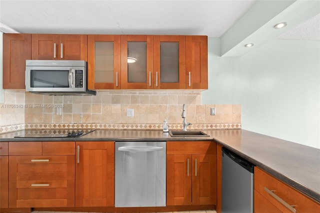 kitchen with appliances with stainless steel finishes, tasteful backsplash, and sink