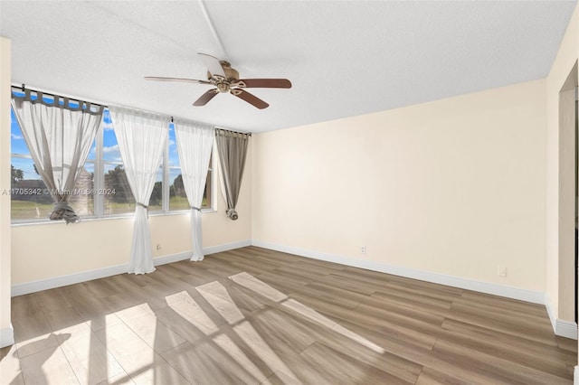 empty room featuring ceiling fan, a textured ceiling, and hardwood / wood-style flooring