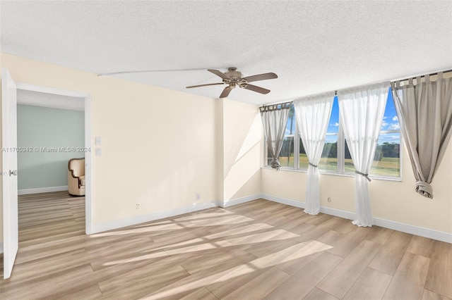 spare room with a textured ceiling, light hardwood / wood-style flooring, and ceiling fan