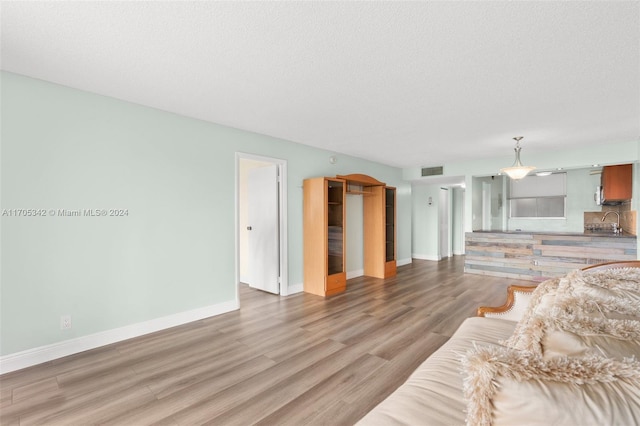 living room featuring hardwood / wood-style floors, a textured ceiling, and sink