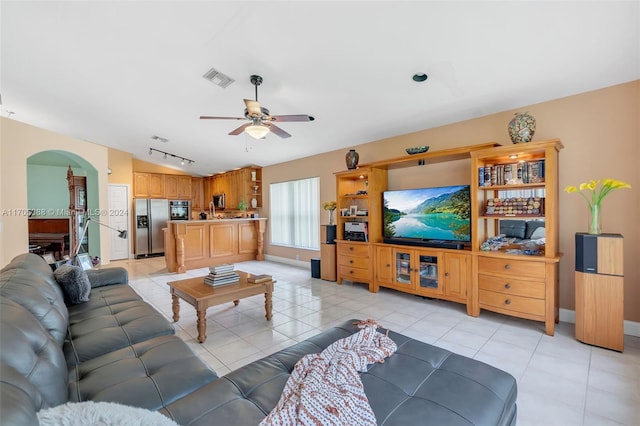 tiled living room featuring ceiling fan and lofted ceiling