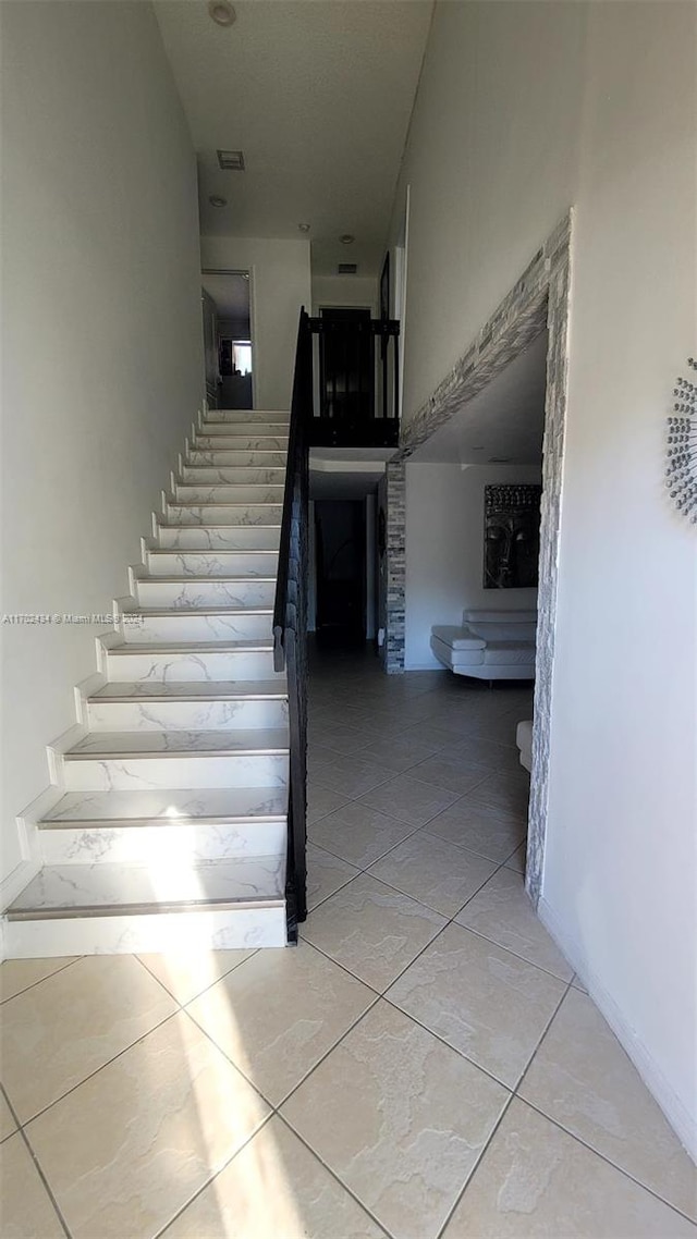 stairway featuring tile patterned floors