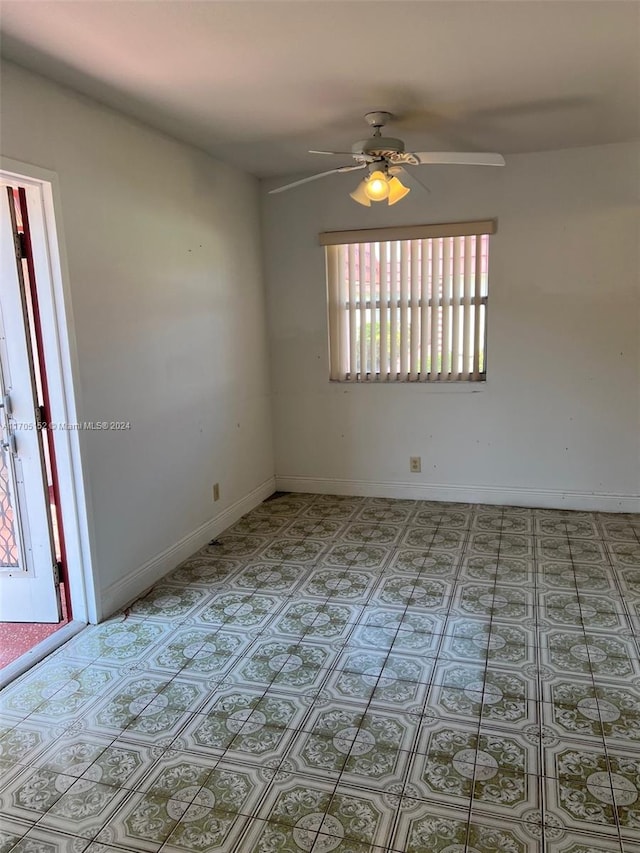 tiled spare room featuring ceiling fan