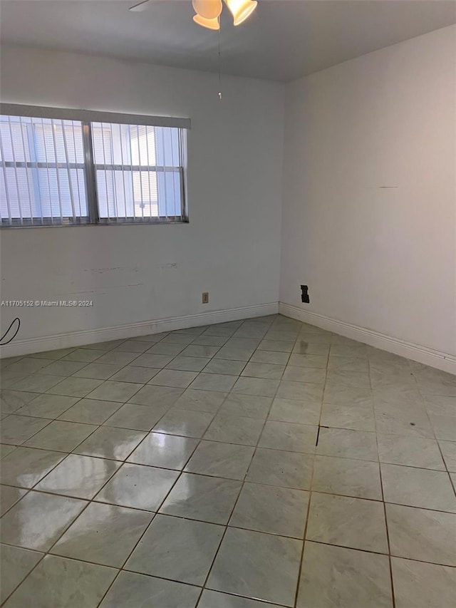 unfurnished room with ceiling fan and light tile patterned floors