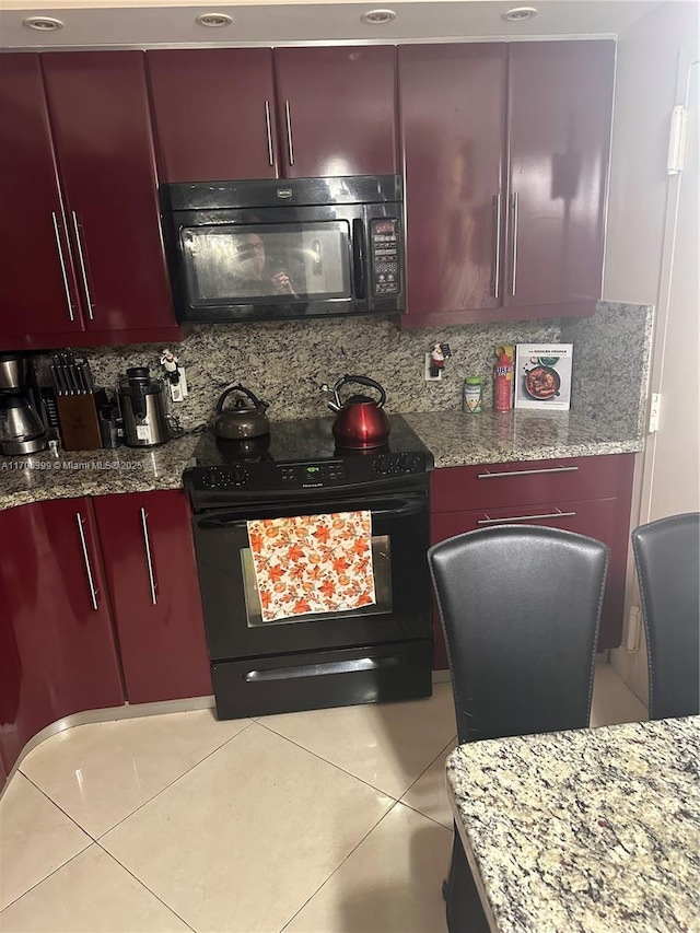 kitchen with light tile patterned floors, decorative backsplash, stone countertops, and black appliances