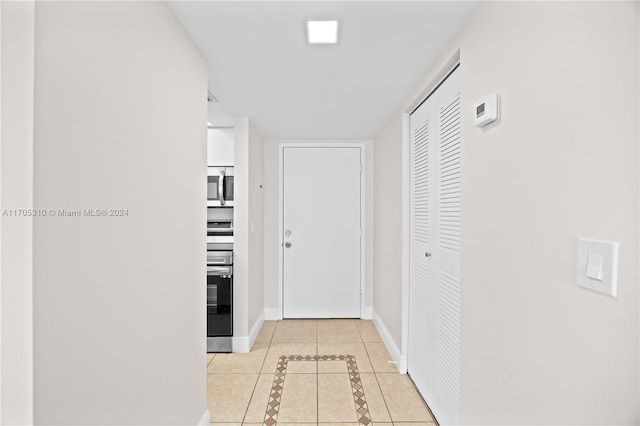 hall with light tile patterned floors