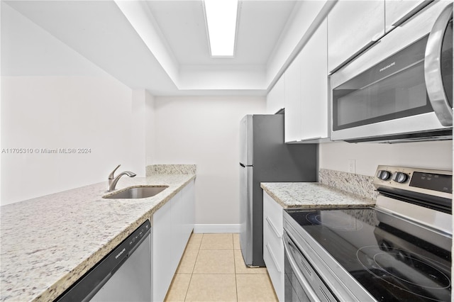 kitchen featuring white cabinetry, sink, light stone counters, and appliances with stainless steel finishes