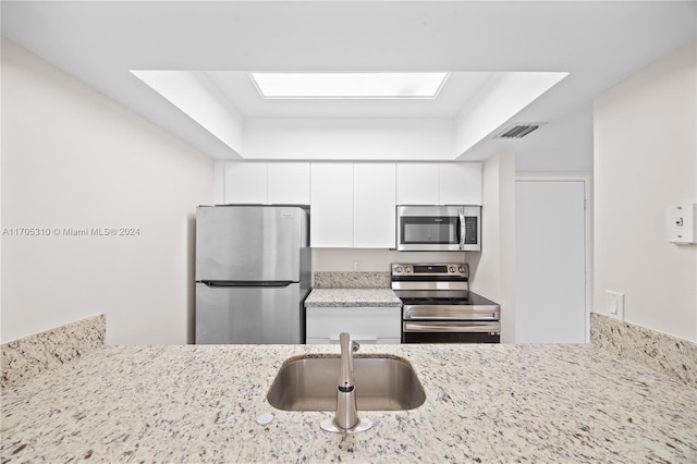 10001 W Atlantic Blvd Unit 316, Coral Springs, FL 33071 - kitchen with appliances with stainless steel finishes, white cabinetry, and light stone countertops