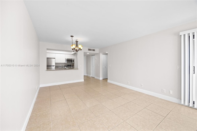 unfurnished living room featuring light tile patterned floors and a chandelier