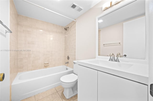 full bathroom featuring tile patterned floors, tiled shower / bath combo, toilet, and vanity