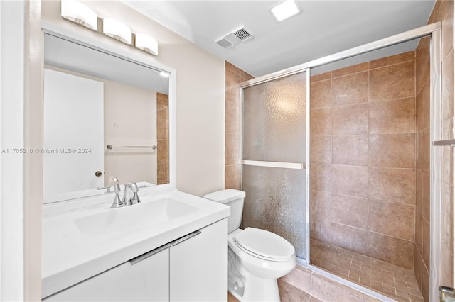 bathroom featuring tile patterned flooring, vanity, an enclosed shower, and toilet