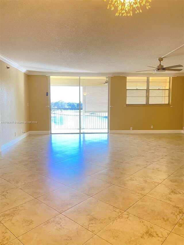 spare room with floor to ceiling windows, a textured ceiling, ceiling fan, and crown molding