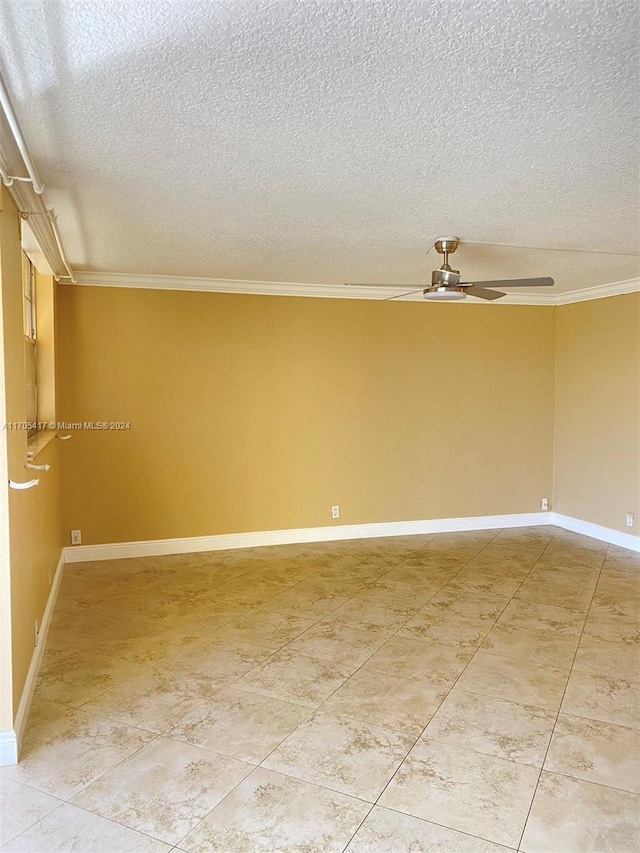 empty room featuring ceiling fan, a textured ceiling, and ornamental molding