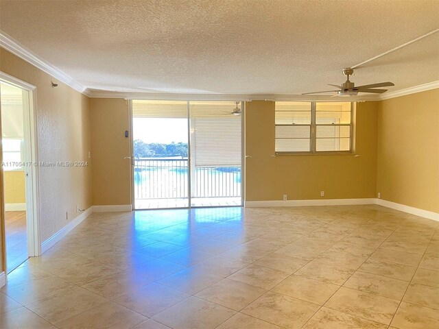 empty room with ceiling fan, crown molding, and a textured ceiling