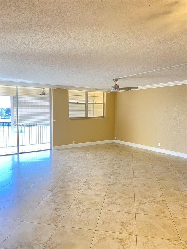 unfurnished room featuring ceiling fan, a healthy amount of sunlight, crown molding, and a textured ceiling