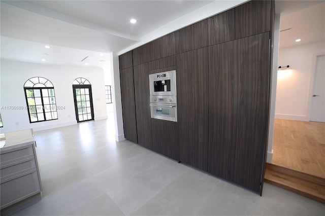 kitchen featuring stainless steel double oven and dark brown cabinetry