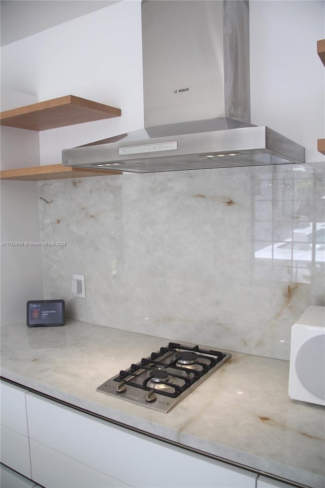 kitchen featuring stainless steel gas cooktop and wall chimney range hood