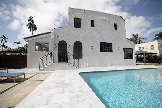 rear view of property featuring a gazebo and a patio