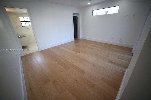 empty room with light hardwood / wood-style flooring and plenty of natural light