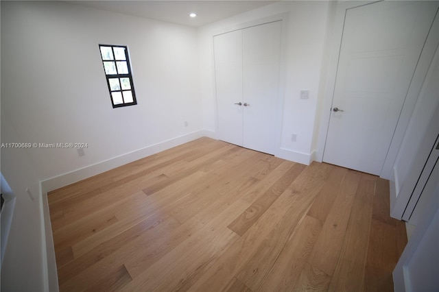 unfurnished bedroom with a closet and light hardwood / wood-style flooring