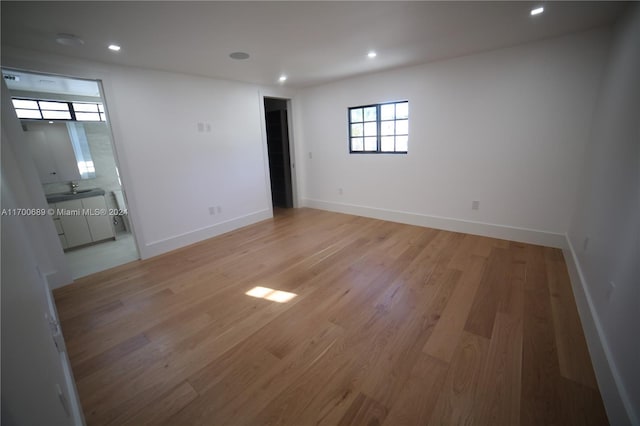 spare room featuring sink and light hardwood / wood-style floors