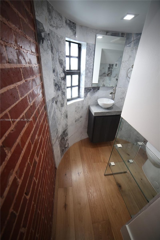 bathroom featuring wood-type flooring, vanity, and toilet