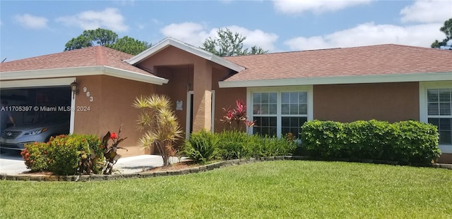 view of front of property with a garage and a front lawn