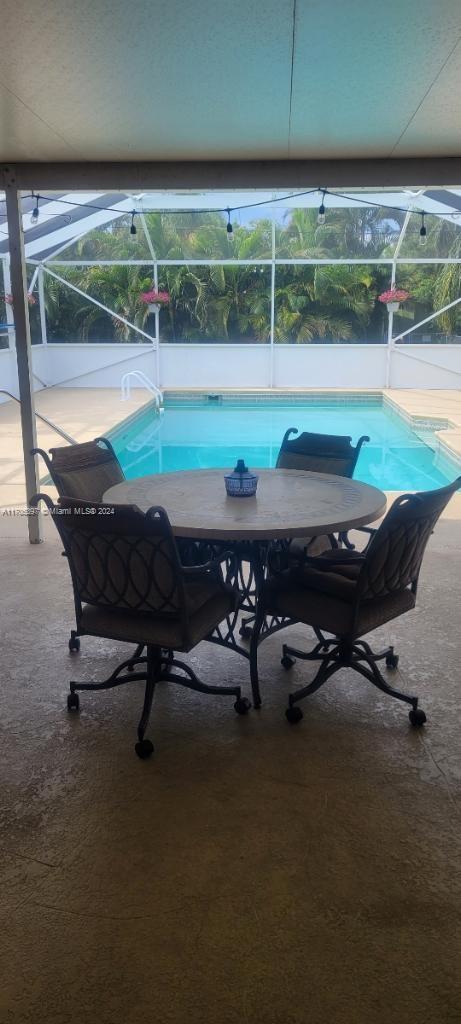 view of swimming pool with a patio and a lanai