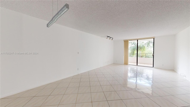 tiled empty room with a textured ceiling